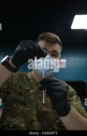 Spc. Kirkland Schramm, ein Kampfmediziner mit dem Division Special Trupps Bataillon MEDOPS, 3rd Division Sustainment Brigade, bereitet sich darauf vor, einem US-Soldaten im Camp Arifjan, Kuwait, den Impfstoff Moderna COVID-19 zu verabreichen, den 17. August. Sanitäter in Camp Arifjan führten eine COVID-19-Impfstofftmpfung für Personal durch, das nicht vollständig geimpft wurde. Stockfoto