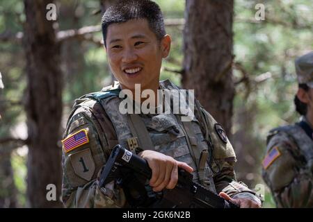 Personal Sgt. Eric Hsu, ein Personalspezialist bei der 376. Human Resources Company in Bell, Kalifornien, spricht nach einem zivilen Protestszenario bei einer Combat Support Training Exercise (CSTX) in Fort McCoy, Wisconsin, am 17. August 2021 mit seinem Team. CSTX ermöglicht es Einheiten der Nationalgarde und der Armeereserven, die Bereitschaft zur Vorbereitung auf zukünftige Kampfeinsätze durch realistische Szenarien zu erreichen, zu verbessern und aufrechtzuerhalten, die von Beobachtern, Trainern und Trainern bewertet werden. Stockfoto