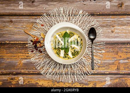 Draufsicht auf köstlichen Palak Paneer mit Spinat und gutem Kraut mit schwarzer Cuchara und hölzernen Teelöffel mit Nüssen Stockfoto