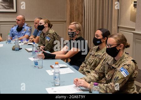 Mitglieder der Kosovo Police und der Kosovo Force 29 Regional Command-East Soldaten nehmen am Frauenverband der Kosovo Police Teil, dem „Leadership Training Day“, im Villa Germia Restaurant Pristina in Pristina, Kosovo, 18. August 2021. Die Hauptredaentin, Oberstin der Polizei des Kosovo, Aferdita Mikullovci, moderiert die Diskussion und teilt ihre persönliche Reise in Führungsbereiche. Der professionelle Dolmetscherin, Center in schwarz, hilft, die Sprachbarrieren zu überbrücken. Zu den unterstützenden Organisationen gehören das General Police Directorate und die US-Botschaft im Kosovo. Stockfoto