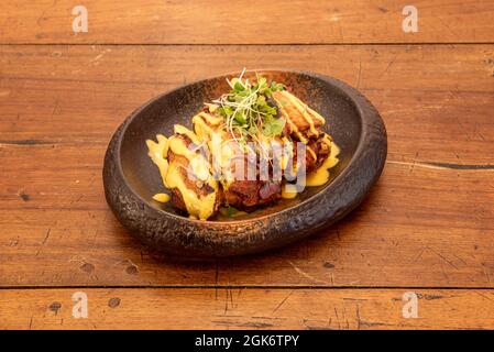 Chicken Wings Rezept überarbeitet mit Techno-emotionale Techniken auf einem schönen tiefen Teller mit Sprossen aus Gemüse Stockfoto