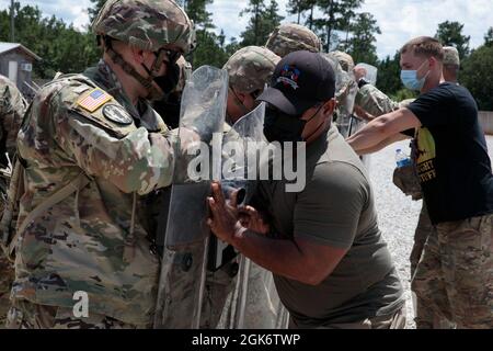 Beobachter, Trainer/Trainer (OCT) mit der 177. Panzerbrigade der Armee agieren als Aggressoren für Reservesoldaten der 477. Militärpolizei während des Trainings für zivile Unruhen am 18. August 2021 im Camp Shelby Joint Forces Training Center. Die 447th MP Co., die ihren Sitz in North Canton, Ohio hat, erhält die Ausbildung als Teil ihrer Mobilisierung für einen Auslandseinsatz zur Unterstützung zukünftiger/laufender Missionen. Stockfoto