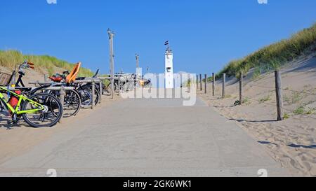 Der Leuchtturm mit der niederländischen Flagge in Noordwijk aan Zee vor dem Eingang zum Strand in den Niederlanden Stockfoto