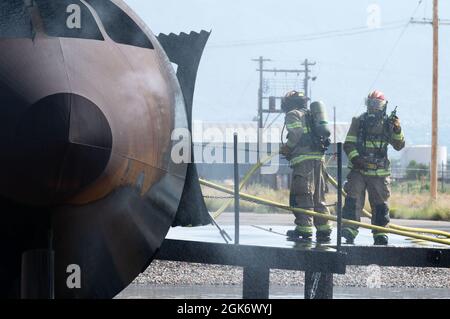 Mitglieder der Feuerwehr der Luftwaffenbasis Kirtland nehmen am 18. August 2021 an einer Live-Feuerübung auf der Luftwaffenbasis Kirtland, New Mexico, Teil. Während der Übung wurde ein lebender Flugzeugbrand simuliert, der von den Feuerwehrleuten gelöscht werden konnte. Diese Simulation übte die Einsatzbereitschaft und die Fähigkeiten des Teams und seiner Partnerstationen aus. Stockfoto