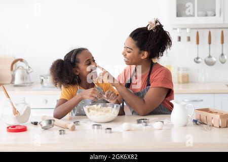 Fröhliche schwarze Mutter und Kind Spaß beim Backen Stockfoto