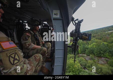 U.S. Army Command Sgt. Maj. Mario Terenas, der Oberfeldwebel Major der 10. Bergdivision, führt am 18. August 2021 in Fort Drum, NY, mit einem 2-10 Assault Helicopter Bataillon Luftgewehrschießen durch. Die Luftpistole bestand darin, aus einem UH-60M Black Hawk einen M240H zu schießen und dabei Bodenziele zu treffen. Stockfoto