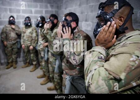 Soldaten der Militärreserve der 447th Military Police Company aus dem Norden von Canton, Ohio, entfernen und überprüfen ihre Masken, während sie CS-Gas während der Einarbeitung in chemische, biologische, radiologische und nukleare (CBRN) Gase ausgesetzt sind, 21. August 2021 im Camp Shelby Joint Training Center, Die Miss. CBRN ist eine Reihe von Trainings, die während der Mobilisierung erforderlich sind und durchgeführt werden, um die Soldaten auf ihren Schutzmasken wieder vertraut zu machen und zu beruhigen. Stockfoto