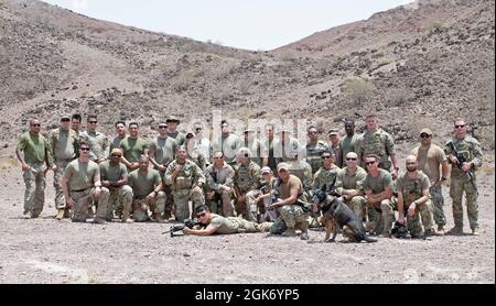 ARTA, Dschibuti (19. August 2021) Mitglieder der US-Armee und der US-Marine versammeln sich nach einer erfolgreichen Live-Feuerübung am Dschibuti Range Complex, Dschibuti, 19. August 2021, zu einem Gruppenfoto. Die Dienstmitglieder sind alle derzeit im Camp Lemonnier, Dschibuti (CLDJ) stationiert, das als Expeditionierungsbasis für US-Streitkräfte dient, die Schiffe, Flugzeuge und Personal unterstützen, die die Sicherheit in ganz Europa, Afrika und Südwestasien gewährleisten. CLDJ ermöglicht See- und Kampfeinsätze am Horn von Afrika und fördert gleichzeitig positive Beziehungen zwischen den USA und Afrika. Die Basis ist auch die Heimat von Co Stockfoto