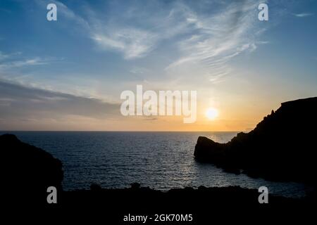 Sonnenuntergang an einem schönen Frühlingstag mit ruhigem Meer, von Anchor Bay, Mellieha, Malta aus gesehen. Stockfoto