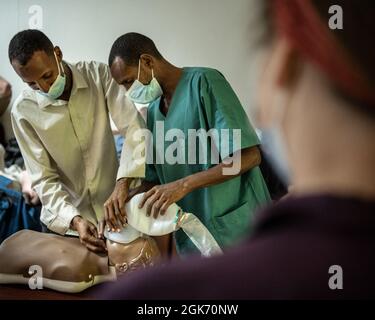 Dschibutianische Gesundheitsdienstleister führen eine HLW durch, während sie mit der US-Militärkapitätin Jessica Campion, Krankenschwester, Civil Affairs Functional Specialty Team, Southern European Task Force – Africa (SETAF-AF), während eines Austauschs bewährter CPR-Verfahren im Ali Sabieh Hospital, Dschibuti, am 19. August 2021, zusammenarbeiten. Das Engagement diente dazu, die richtigen HLW-Praktiken bei Erwachsenen, Jugendlichen und Säuglingen durch einen Austausch von Techniken, Erfahrungen und praktischen Demonstrationen zu verstärken. Zivile Soldaten, die in Camp Lemonnier, Dschibuti, stationiert sind, führen regelmäßig zivil-militärische Operationen in der Region durch. Zivil Stockfoto