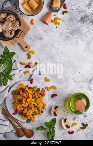 Pasta. italienische Pasta. Insalata di Pasta und Gemüse Kochzutaten, Käse, Pilze und Basilikum auf altem Steingrund. Italienische Küche Stockfoto