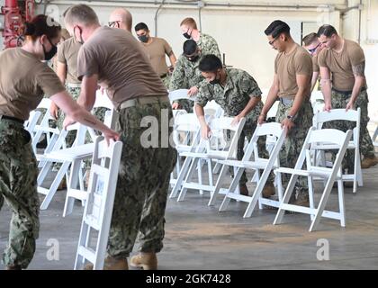 210820-N-GK686-1070 MARINELUFTSTATION SIGONELLA, ITALIEN (AUG 20, 2021) Seeleute, die dem U.S. Navy Medical Readiness and Training Command Sigonella zugewiesen sind, bewegen Stühle, um den Aufnahmebereich an Bord der Naval Air Station Sigonella vorzubereiten, um die Mission des Verteidigungsministeriums zu unterstützen, um die sichere Ausreise und Umsiedlung von US-Bürgern, Special Immigration Visa Empfängern, Und der gefährdeten afghanischen Bevölkerung aus Afghanistan, 20,2021. August. Stockfoto