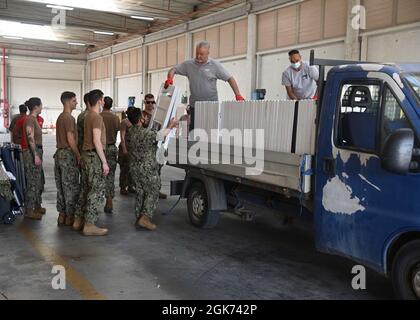 210820-N-GK686-1056 MARINELUFTSTATION SIGONELLA, ITALIEN (AUG 20, 2021) Seeleute, die dem U.S. Navy Medical Readiness and Training Command Sigonella zugewiesen sind, bewegen Stühle, um den Aufnahmebereich an Bord der Naval Air Station Sigonella vorzubereiten, um die Mission des Verteidigungsministeriums zu unterstützen, um die sichere Ausreise und Umsiedlung von US-Bürgern, Special Immigration Visa Empfängern, Und gefährdete afghanische Bevölkerungen aus Afghanistan, 20. August 2021. Stockfoto