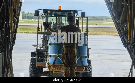 US Air Force Staff Sgt. Davis Moore, eine FLUGTRANSPORTVERBINDUNG UNTER ROTER FLAGGE, die der 354th Operations Group Detachment 1, Joint Base Elmendorf-Richardson, Alaska, zugewiesen ist, betreibt einen Lader, während der US Air Force Airman 1st Class Andrew Harris, ein C-130J Super Hercules Ladermeister mit der 39. Luftlift Squadron der Dyess Air Force Base, Texas, Weist ihn auf die Laderampe während DER RED FLAG-Alaska 21-3 bei JBER, Alaska, am 20. August 2021. Als Teil einer fortlaufenden Übungsserie sind RF-A und sein Vorgänger COPE THUNDER seit mehr als 40 Jahren regelmäßig geplante Übungen, die nicht mit A in Verbindung stehen Stockfoto