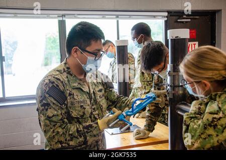 Midshipmänner, die dem NROTC-Programm (Naval Reserve Officers' Training Corps) der Yale University zugewiesen wurden, erhalten am 20. August 2021 an Bord des Naval Submarine Base New London Unterricht im Klassenzimmer sowie praktische Übungen im Naval Submarine School Damage Control Wet Trainer. Der Trainer soll U-Boot-Seeleuten bei der Vorbereitung auf Einsätze unterstützen, indem er Überschwemmungen in einer kontrollierten Umgebung simuliert. Stockfoto