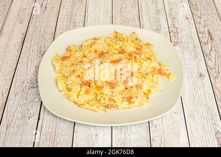 Klassisches Reisgericht drei chinesische Köstlichkeiten mit Karotten, französischem Omelett und Schinken auf weißem Teller. Stockfoto