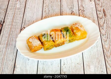 Baklava-Kuchen mit Pistazie, Kokosnuss und Mandel auf einem weißen Tablett Stockfoto