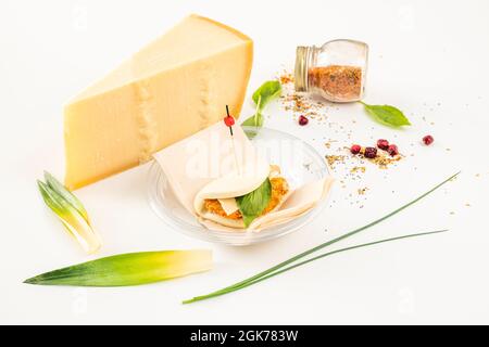 Hühnerbad mit Basilikum, Gewürzen und einer riesigen Scheibe Käse auf dem Rücken Stockfoto