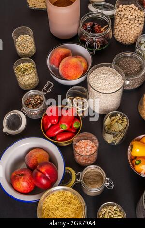 Viele Gläser mit allen Arten von Gewürzen wie Himalaya-Salz, Reis, Paprika, Pasta, Kardamom, Pfirsiche, Kichererbsen, ñoras, Pfeffer, Nektarinen, chia Stockfoto