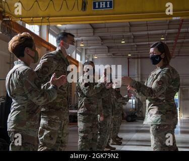 Chief Master Sgt. Der Luftwaffe Joanne S. Bass würdigt die Leistungen von Tech. Sgt. Cristian Jaramillo, Sektionschef des 18. Maintenance Group Maintenance Operations Center, auf dem Luftwaffenstützpunkt Kadena, Japan, 23. August 2021. Während ihres Besuchs bei Kadena ab besuchte sie Chief Master Sgt. Bass tourte durch die Einrichtungen, erkannte Airmen für seine hervorragende Leistung an und sprach während eines gesamten Anrufs die Kultur und die Politik der Luftwaffe an. Stockfoto