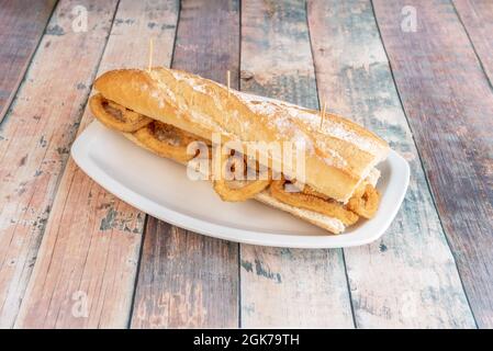 Sandwich aus Tintenfisch-Ringen, zerschlagen mit Mehl und Ei, serviert in einer Tapas-Bar in Madrid Stockfoto