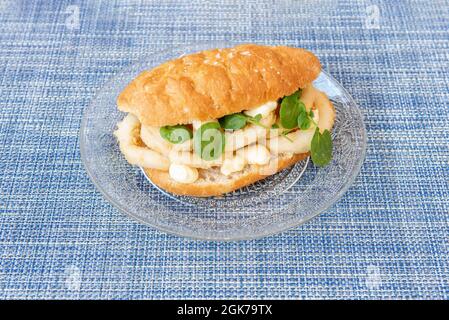 Spanisches Sandwich aus Tintenfischringen, zerschlagen mit Mehl und Ei auf einer Glasplatte Stockfoto