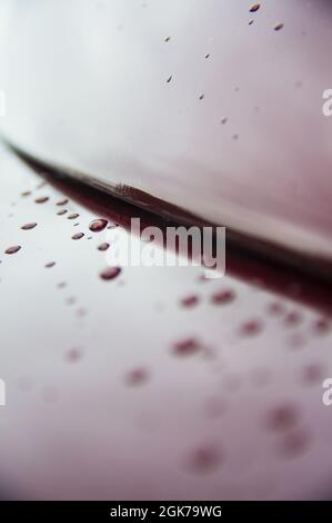 Abstrakt Kunst Textur Hintergrund von Regentropfen auf braun rot glänzend gebürsteten Edelstahl-Metalloberfläche auf alten Retro-Oldtimer Dach und Stoßstange Stockfoto