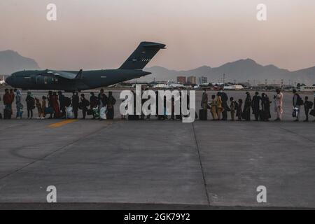 Evakuierte warten während einer Evakuierung auf dem Hamid Karzai International Airport, Kabul, Afghanistan, am 23. August auf den Einsteigen in eine Boeing C-17 Globemaster III. US-Dienstmitglieder unterstützen das Außenministerium bei einer nicht-kämpferischen Evakuierungsoperation (NEO) in Afghanistan. Stockfoto