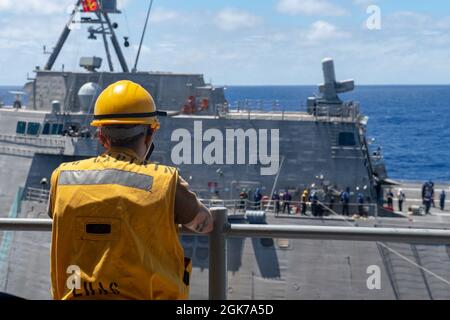 PHILIPPINISCHES MEER (Aug 23, 2021) die Mate 3rd Class Reese Stricklen von Boatswain aus Fort Smith, Ark., die dem nach vorne eingesetzten amphibischen Angriffsschiff USS America (LHA 6) zugeordnet ist, überwacht die Tankstelle während einer Betankung auf See mit dem Küstenkampfschiff USS Charleston (LCS 18). Amerika, das Flaggschiff der America Expeditionary Strike Group, ist zusammen mit der 31. MEU im Verantwortungsbereich der 7. US-Flotte tätig, um die Interoperabilität mit Verbündeten und Partnern zu verbessern und als einsatzbereite Einsatztruppe für Frieden und Stabilität in der Indo-Pazifik-Region zu dienen. Stockfoto