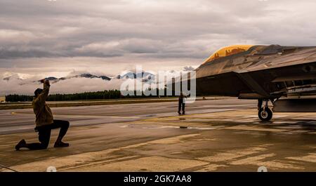 Dailen Holmes, 94th Fighter Squadron F-22 Raptor Crew Chief, hilft bei der Führung eines F-22 Raptor Piloten während der Red Flag Alaska, 21-3 auf der Joint Base Elmendorf-Richardson, Alaska, 23. August 2021. Die Übung „Rote Flagge“ bringt mehrere Staffeln aus der gesamten Luftwaffe zusammen, um eine reale Kampfumgebung zu simulieren. Stockfoto