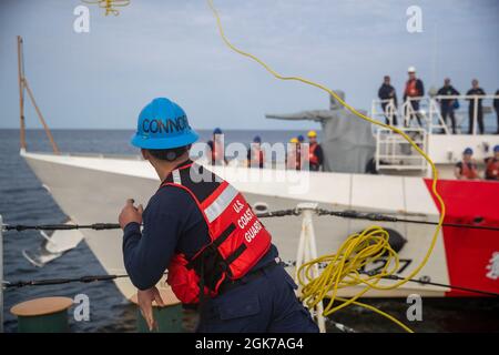 LABRADOR SEA -- (Aug 23, 2021) Seaman Tyler Nava, ein Besatzungsmitglied, das dem USCGC Escanaba (WMEC 907) zugewiesen wurde, wirft die Heaving Line während eines Tankens in der Labradorsee auf den 154-Meter-Schnellabschneider USCGC Richard Snyder (WPC 1127) der Sentinel-Klasse. USCGC Escanaba ist ein 270-Fuß-Cutter für mittlere Ausdauer, bei dem eine Besatzung von rund 100 Personen viele der Missionen des Dienstes durchführt, wobei der Schwerpunkt auf Strafverfolgung und Sicherheit liegt. Stockfoto