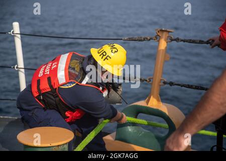 LABRADOR SEA -- (Aug 23, 2021) Petty Officer 3rd Class Logan Murphy, ein Bootsmann und Besatzungsmitglied, das der USCGC Escanaba (WMEC 907) zugewiesen wurde, arbeitet während einer Auftankungsentwicklung in der Labradorsee eine Linie zum 154-Fuß-Sentinel-Klasse-USCGC Richard Snyder (WPC 1127). USCGC Escanaba ist ein 270-Fuß-Cutter für mittlere Ausdauer, bei dem eine Besatzung von rund 100 Personen viele der Missionen des Dienstes durchführt, wobei der Schwerpunkt auf Strafverfolgung und Sicherheit liegt. Stockfoto