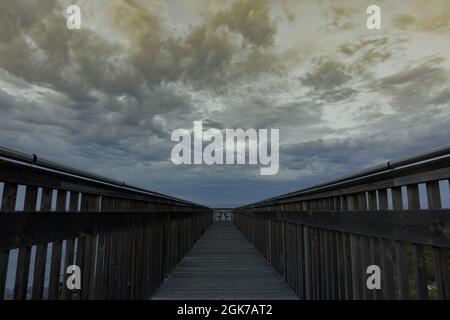 Dämmerungswolken bilden sich über der Promenade von Palo Alto Baylands. Santa Clara County, Kalifornien, USA. Stockfoto