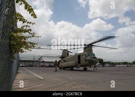 Luftbesatzung mit dem 1. Bataillon, 228. Luftfahrtregiment, Joint Task Force-Bravo, Soto Cano Air Base, Honduras, bereiten sich darauf vor, nach einer Katastrophenhilfe in Port-au-Prince, Haiti, am 24. August 2021 einen Patienten an freiwillige Helfer zu liefern. Auf Ersuchen des US-Südkommandos entsandt, um Hilfsmaßnahmen für die Menschen in Haiti zu unterstützen, nachdem die Nation am 14. August von einem Erdbeben getroffen wurde. Stockfoto