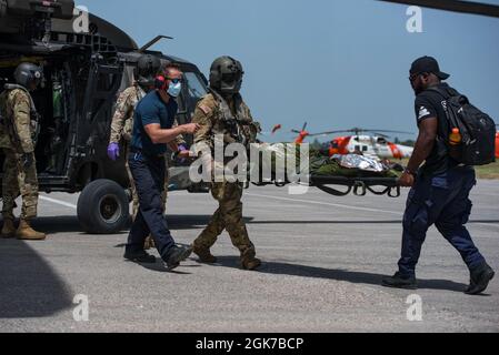 Freiwillige medizinische Helfer und die Luftbesatzung mit dem 1. Bataillon, dem 228. Luftfahrtregiment, der Joint Task Force-Bravo, dem Soto Cano Air Base, Honduras, entladen während einer medizinischen Evakuierungsmission in Port-au-Prince, Haiti, am 24. August 2021 Patienten aus einem Hubschrauber der UH-60 Black Hawk. Auf Ersuchen des U.S. Southern Command entsandt, um Hilfsmaßnahmen für die Menschen in Haiti zu unterstützen, nachdem die Nation am 14. August von einem Erdbeben getroffen wurde. Stockfoto