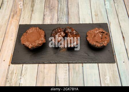 Schokoladen-Brownies und Schokoladenschokolade auf schwarzem Schieferteller Stockfoto