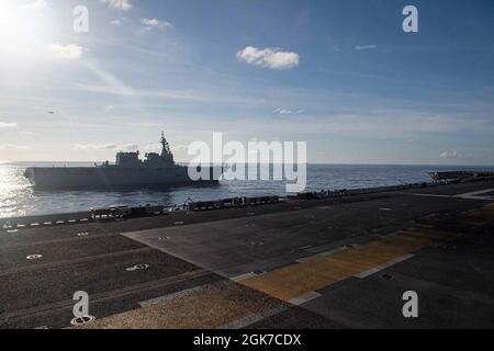 PHILIPPINISCHES MEER (Aug 24, 2021) der Zerstörer der japanischen Maritime Self-Defense Force JS Ise (DD 182) segelt in Formation mit dem nach vorne eingesetzten amphibischen Sturmschiff USS America (LHA 6). Amerika, das Flaggschiff der America Expeditionary Strike Group, und die 31. Marine Expeditionary Unit sind im Verantwortungsbereich der 7. Flotte der USA tätig, um die Interoperabilität mit Verbündeten und Partnern zu verbessern und als einsatzbereite Einsatztruppe für Frieden und Stabilität in der Indo-Pazifik-Region zu dienen. Stockfoto