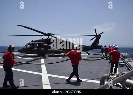 210824-N-N3764-0002 KARIBISCHES MEER - (AUG 24, 2021) – Seeleute, die dem Spearhead-Klasse Expeditions-Schnelltransportschiff USNS Burlington (T-EPF 10) zugewiesen wurden, bereiten sich darauf vor, einen Hubschrauber der US-Armee UH-60 Blackhawk auf dem Flugdeck aufzutanken, 24. August 2021. Burlington wird nach einem Erdbeben der Stärke 7.2 am 14. August 2021 bei den U.S. Naval Forces Southern Command/U.S. 4th Fleet eingesetzt, um humanitäre Hilfe und Katastrophenhilfe (HADR) in Haiti zu unterstützen. Stockfoto