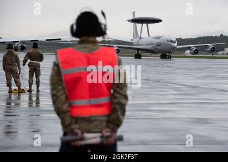 Wartungspersonal der US-Luftwaffe, die dem 718. Flugzeug-Wartungsgeschwader zugewiesen wurde, bereiten sich darauf vor, eine E-3-Überwachung vom 961. Airborne Air Control Squadron zurückzuholen, während es während der Übung RED FLAG-Alaska 21-3 auf der Joint Base Elmendorf-Richardson, Alaska, 25. August 2021, auf die Fluglinie taxis. RF-A 21-3 ist eine von den Pacific Air Forces gesponserte Übung, die durch eine Reihe von befehlsgeleiteten Feldtrainingsmissionen, die gemeinsame Offensive, Gegenluft, Verbot, Unterstützung aus der nahen Luft und Ausbildung von Großkräften in einem simulierten Kampfumfeld bieten soll. Der 718. AMXS Stockfoto