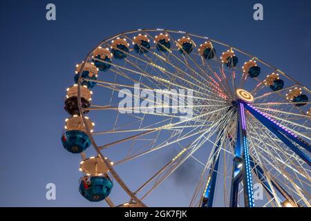 Low Angle View der Spinnen weiß Riesenrad mit blau beleuchtetem Licht gegen Nacht dunklen Himmel. Stockfoto