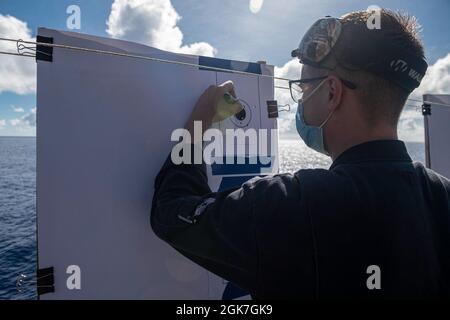 PHILIPPINISCHES MEER (Aug 25, 2021) Gunners Mate 3rd Class Timothy Terry aus Lumberton, Texas, der dem nach vorne eingesetzten amphibischen Angriffsschiff USS America (LHA 6) zugeordnet ist, erzielt bei der Qualifikation der Gewehr auf einem der Flugzeugaufzüge des Schiffes ein Papierziel. Amerika, das Flaggschiff der America Expeditionary Strike Group, und die 31. Marine Expeditionary Unit sind im Verantwortungsbereich der 7. Flotte der USA tätig, um die Interoperabilität mit Verbündeten und Partnern zu verbessern und als einsatzbereite Einsatztruppe für Frieden und Stabilität in der Indo-Pazifik-Region zu dienen. Stockfoto