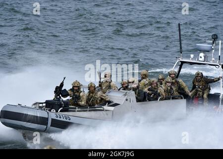 Die Mitglieder des Teams West der US-Küstenwache für maritime Sicherheitskräfte stehen am Donnerstag, den 26. August 2021, während einer Strafverfolgungsübung auf dem Columbia River zwischen Washington und Oregon auf der Suche nach einem Aussichtspunkt. Die MSRT der Küstenwache ist eine taktische Einheit, die sich auf die Bekämpfung des Terrorismus im Seeverkehr und die Durchsetzung risikoreichen Rechts spezialisiert hat. Stockfoto