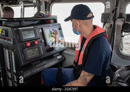 Petty Officer 3rd Class Joshua Shubin betreibt die Navigationseinheit auf einem 45-Fuß-Boot-Medium in Brunswick, Georgia, 26. August 2021. Jede Woche bringt Station Brunswick zwei Boote in Gang, um die Qualifikationsstandards für Besatzungsmacht zu trainieren und aufrechtzuerhalten. ( Stockfoto