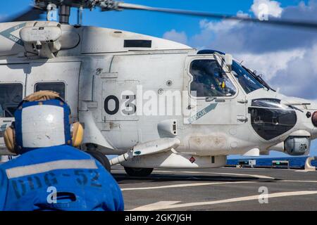 PHILIPPINISCHES MEER (Aug 26, 2021) Während MALABAR 2021 landet Ein Superhawk der japanischen Maritime Self-Defense Force auf dem Flugdeck des Arleigh Burke-Klasse Lenkflugkörper-Zerstörers USS Barry (DDG 52). Barry ist derzeit im Einsatz und unterstützt Commander, Task Force 71 (CTF 71)/Destroyer Squadron 15 (DESRON 15), die größte vorwärtseingesetzte DESRON der Marine und die wichtigste Surface Force der 7. US-Flotte. Stockfoto