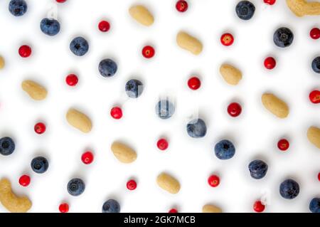 Vollformat Nahaufnahme Waldfrüchte frische Beeren bunt gemischt große Mischung im Studio auf weißem Hintergrund. Isolierte leckere Essensmuster aus Erdnüssen, Cashewkernen, domestizierten, wilden Blaubeeren, Preiselbeeren Stockfoto