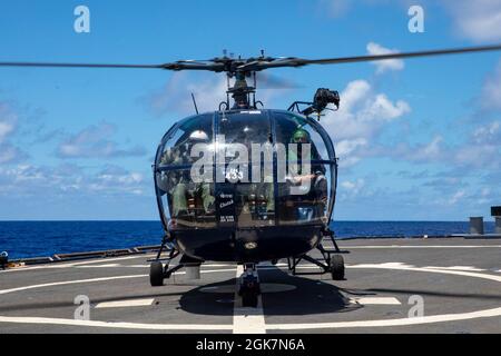 PHILIPPINISCHES MEER (Aug 26, 2021) – ein Chetak-Hubschrauber der indischen Marine landet auf dem Flugdeck des Arleigh Burke-Klasse-Lenkflugkörper-Zerstörers USS Barry (DDG 52) während MALABAR 2021. Barry ist derzeit im Einsatz und unterstützt Commander, Task Force 71 (CTF 71)/Destroyer Squadron 15 (DESRON 15), die größte vorwärtseingesetzte DESRON der Marine und die wichtigste Surface Force der 7. US-Flotte. Stockfoto