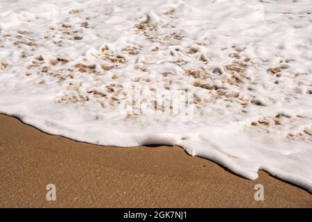 Ocean Nature-Bild mit Nahaufnahme von Details wie schaumiges Wasser, während die Wellen am Strand an der Küste aufspühlen Stockfoto
