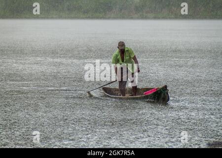 PORTOBELO, PANAMA - 28. MAI 2016: Einheimischer in seinem Kanu bei starkem Regen. Stockfoto