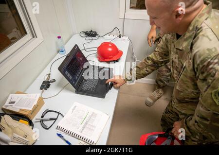 Brig. General Gerald Donohue, Kommandant des 379. Air Expeditionary Wings, schaltet am 29. August 2021 auf der Al Udeid Air Base, Katar, die Stromversorgung für ein neu installiertes Kraftwerk ein. Die 1. Expeditionary Civil Engineering Group hat kürzlich das Kraftwerk aufgebaut, das Zelte mit Strom versorgt, die Evakuierten in Afghanistan temporäre Lebensräume bieten, während sie auf Flüge zum nächsten Ziel warten. Stockfoto