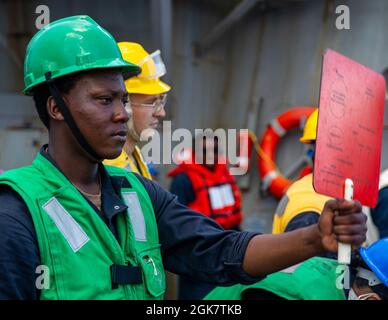 PHILIPPINISCHES MEER (Aug 29, 2021) Seaman Gerrod Collins aus Miami meldet das Henry J. Kaiser-Klasse-Trockenfrachtschiff USNS Yukon (T-AO 202) von den Wetterdecks des Arleigh Burke-Klasse Lenkraketen-Zerstörers USS Barry (DDG 52) während einer Auffüllung auf See als Teil von MALABAR 2021. Barry wird derzeit zur Unterstützung von Commander, Task Force (CTF) 71/Destroyer Squadron (DESRON) 15, der größten vorwärtseingesetzten DESRON der Marine und der wichtigsten Surface Force der US-Flotte der 7. Flotte eingesetzt. Stockfoto